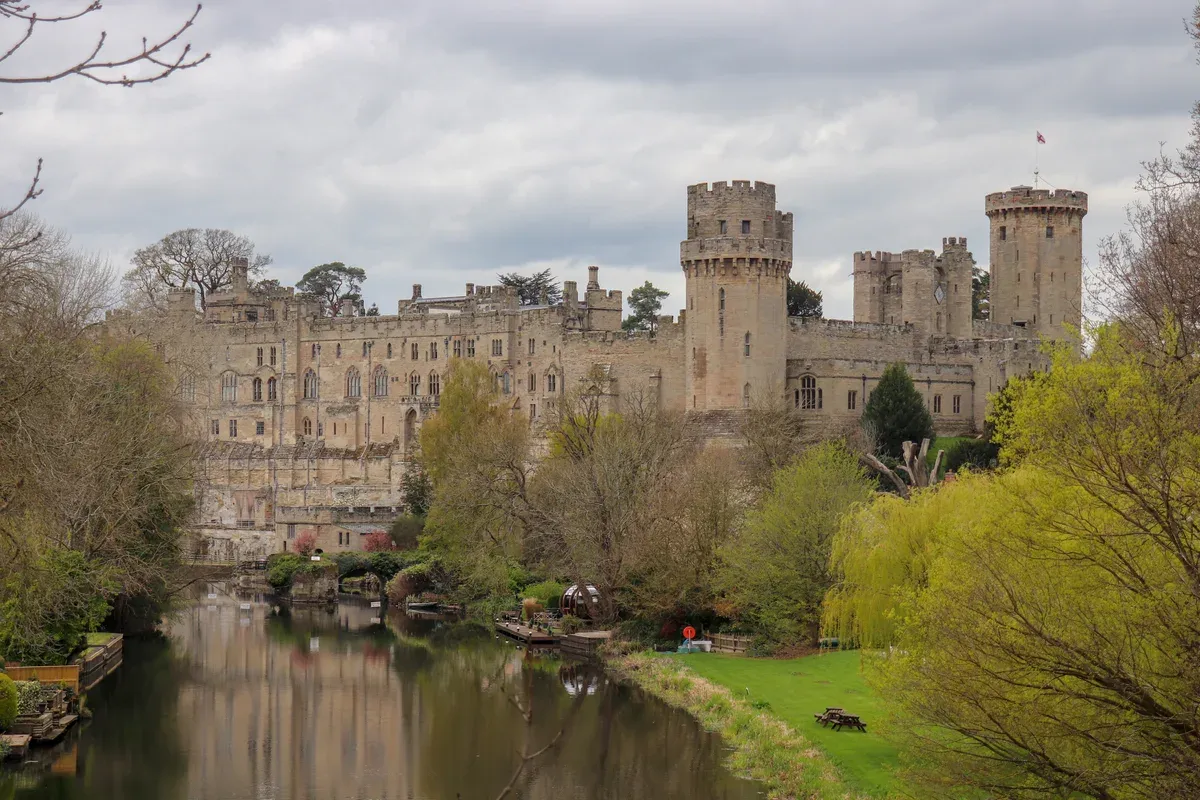Warwick Castle above the River Avon seen from Castle Bridge on a Stratford and Warwick Castle day trip from London